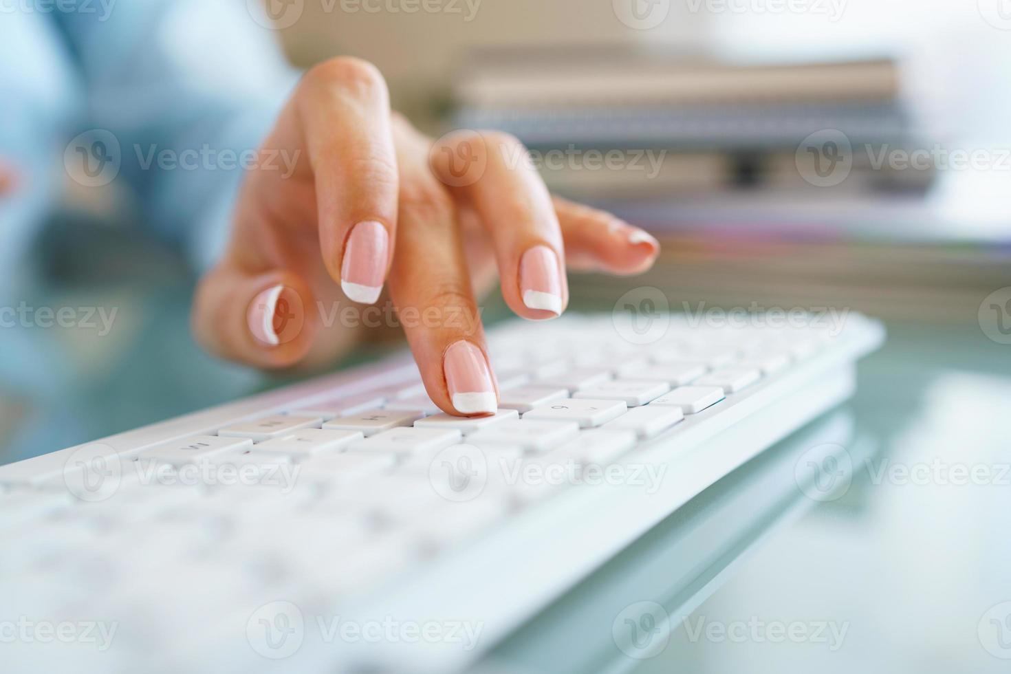 donna ufficio lavoratore digitando su il tastiera foto