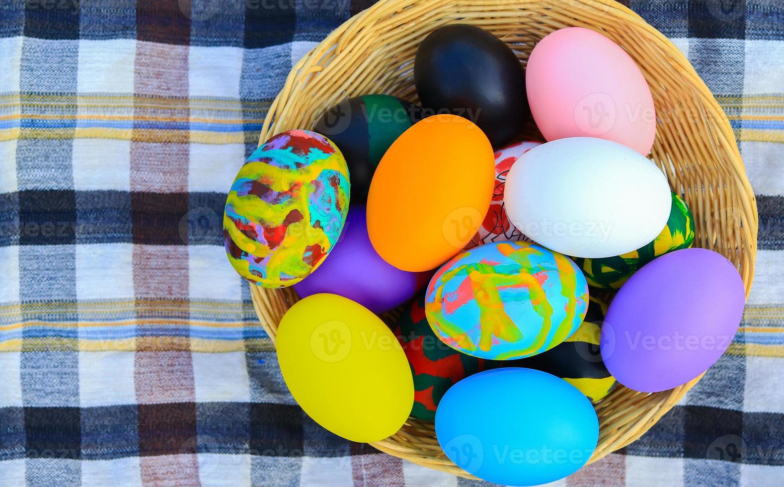 belle uova di Pasqua colorate in un cesto per il giorno di Pasqua foto