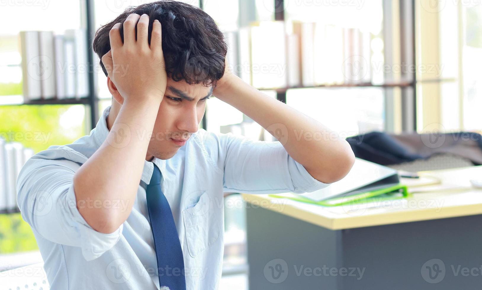 giovane uomo d'affari che lavora in ufficio con lo stress foto