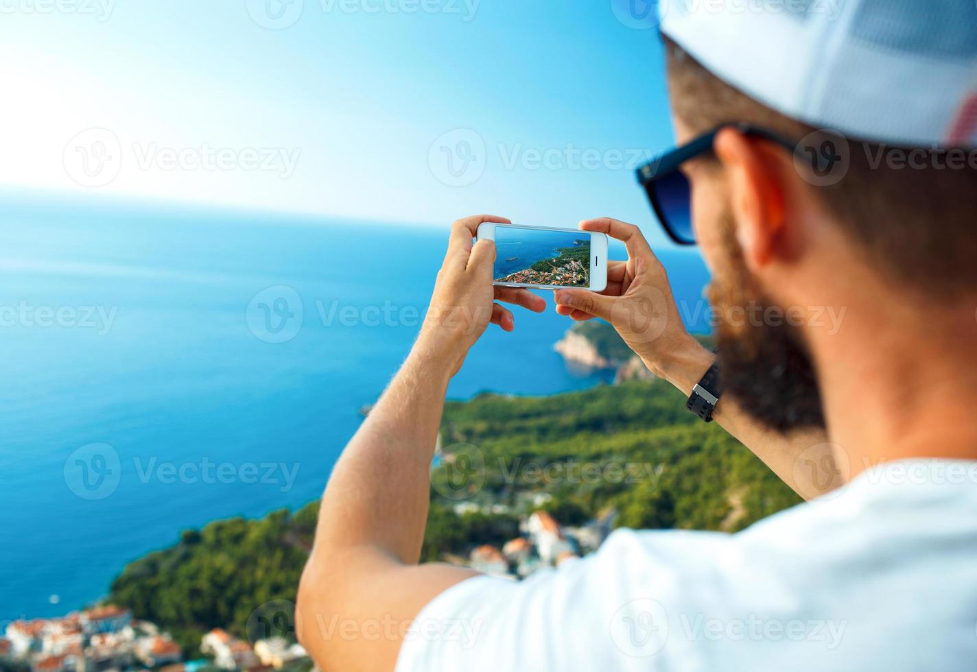 uomo fa fotografie di un' smartphone su il sfondo di mare costa, Adriatico mare