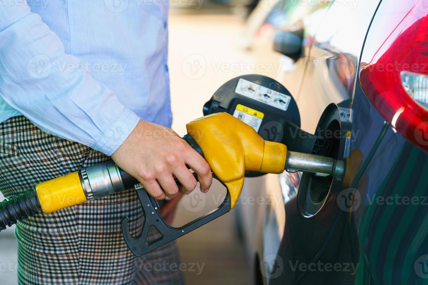 donna riempimenti benzina in il auto a un' gas stazione foto