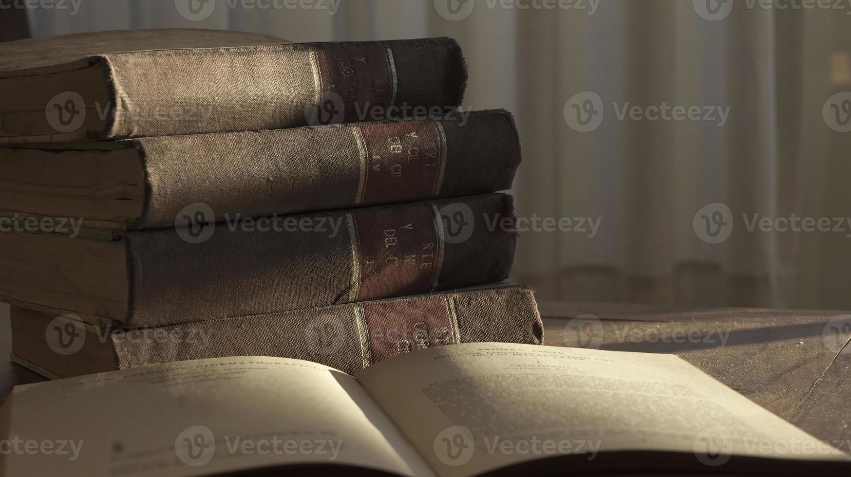 Aperto vecchio libro e mucchio di vecchio libri su un' di legno tavolo su Alba leggero foto