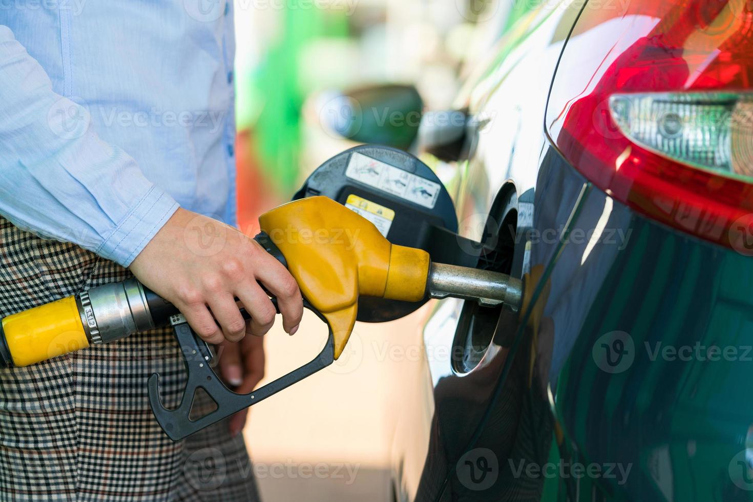 donna riempimenti benzina in il auto a un' gas stazione foto