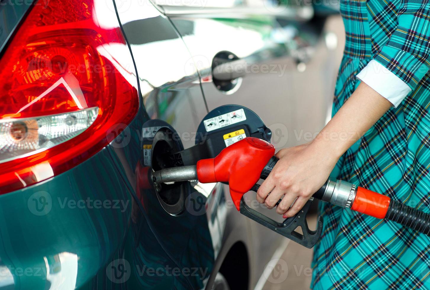 donna riempimenti benzina in il auto a un' gas stazione foto