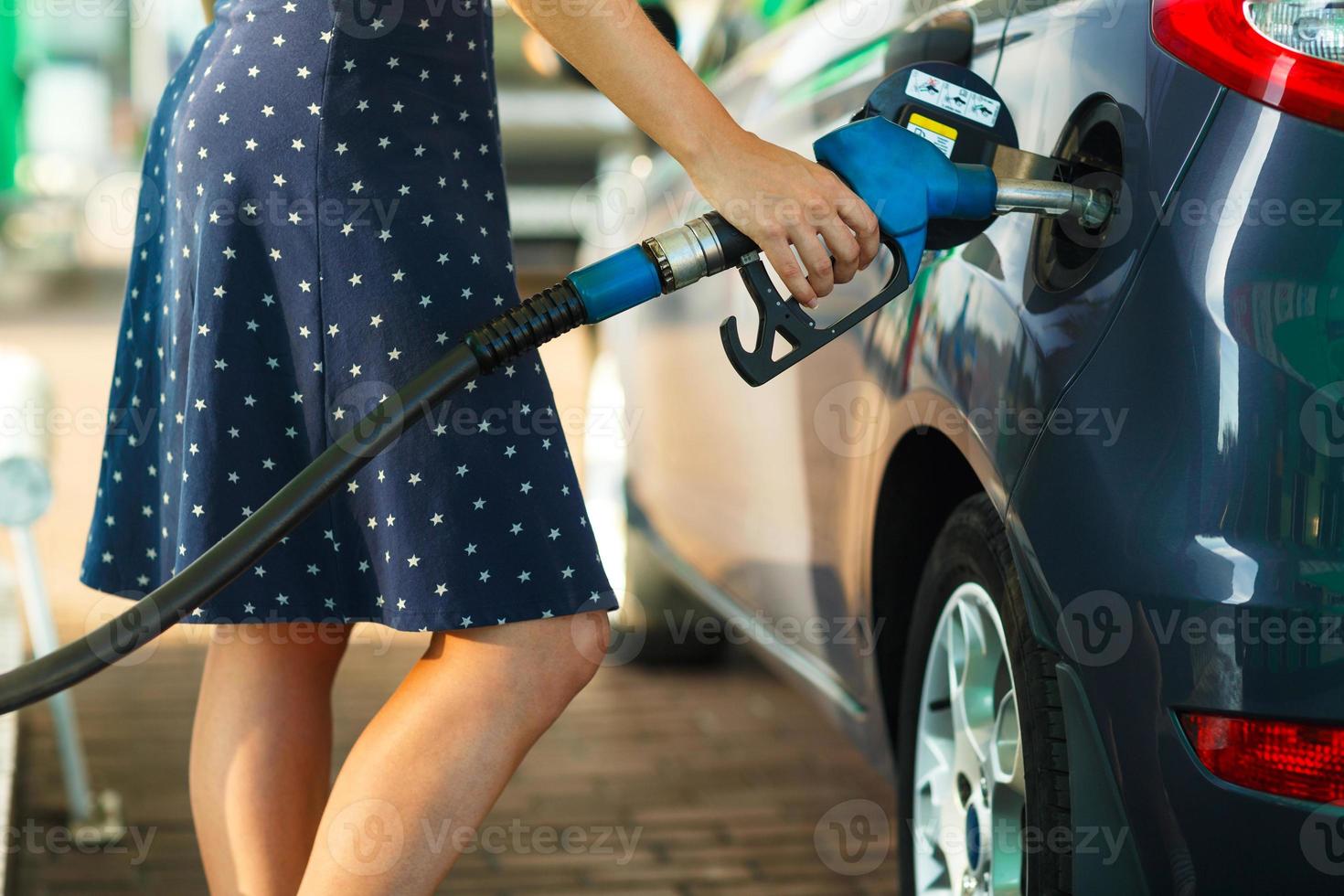 donna riempimenti benzina in il auto a un' gas stazione foto