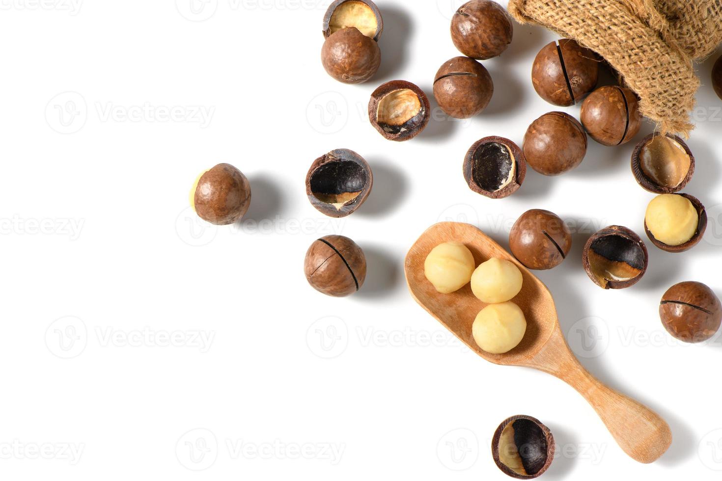 pelato macadamia noccioline nel legna cucchiaio isolato su bianca sfondo, foto