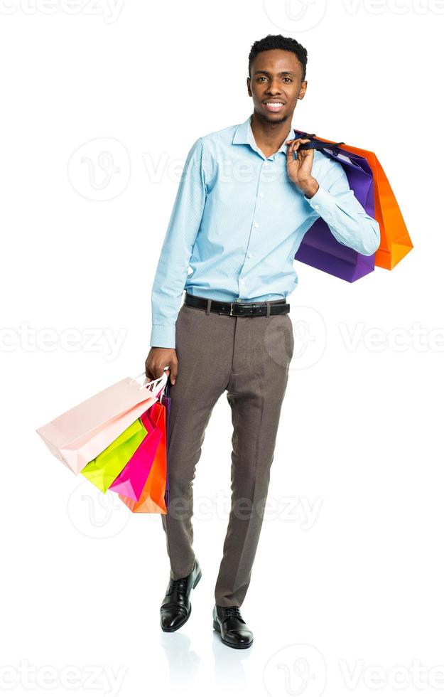 contento africano americano uomo Tenere shopping borse su bianca. vacanze concetto foto