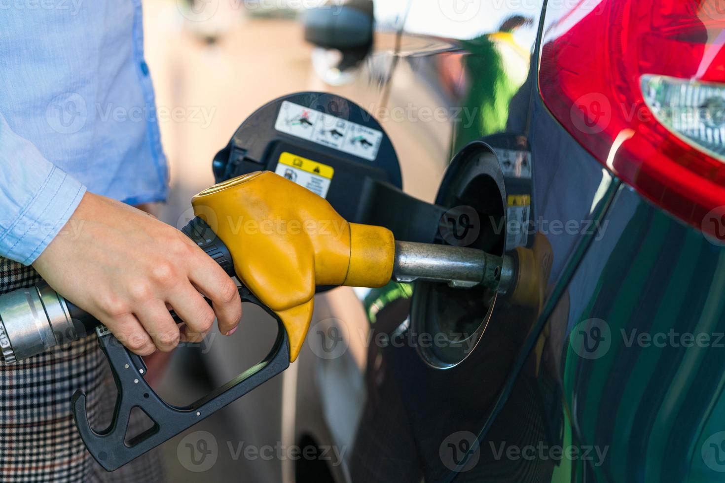 donna riempimenti benzina in il auto a un' gas stazione foto