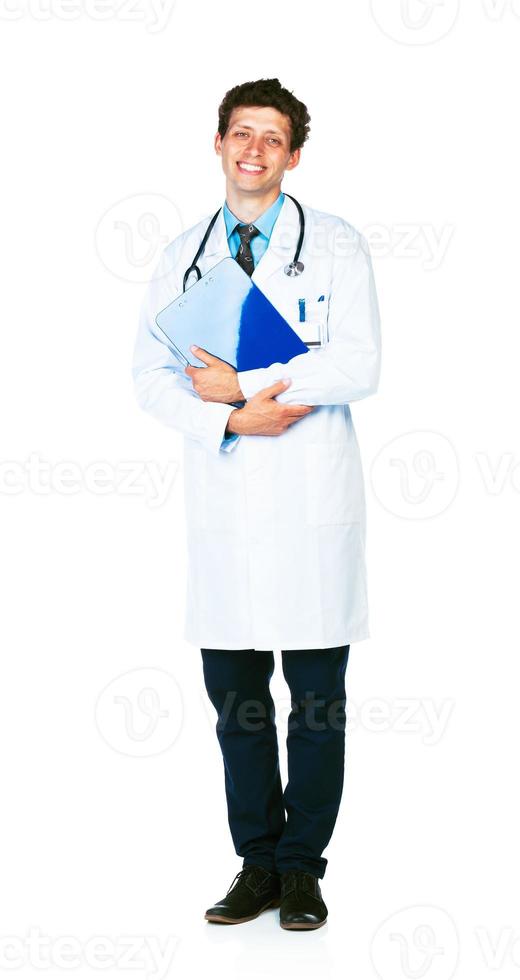 pieno lunghezza ritratto di un' sorridente maschio medico Tenere un' bloc notes su bianca foto