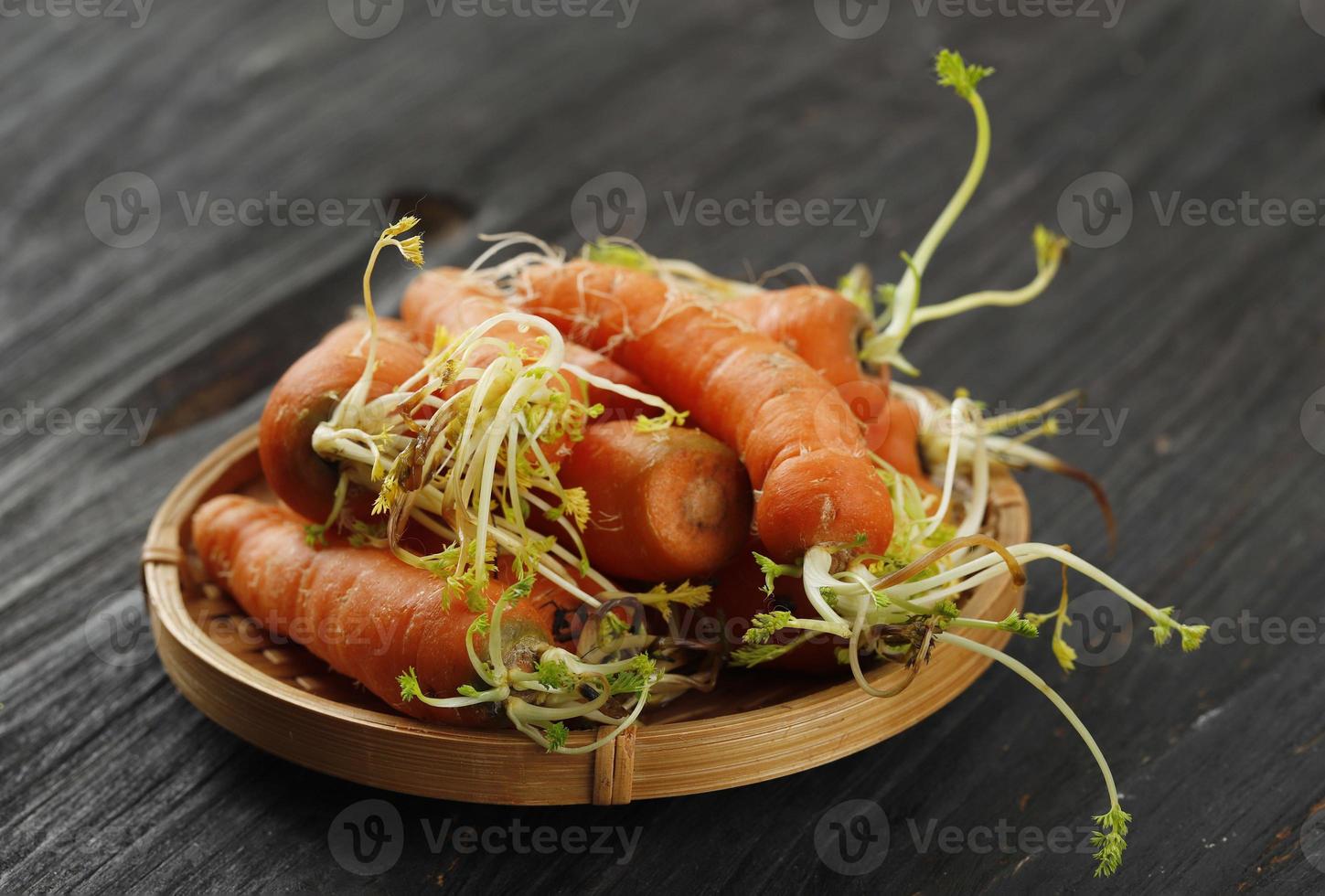 non fresco marcio carota, carota wth germoglio su bambù piatto foto