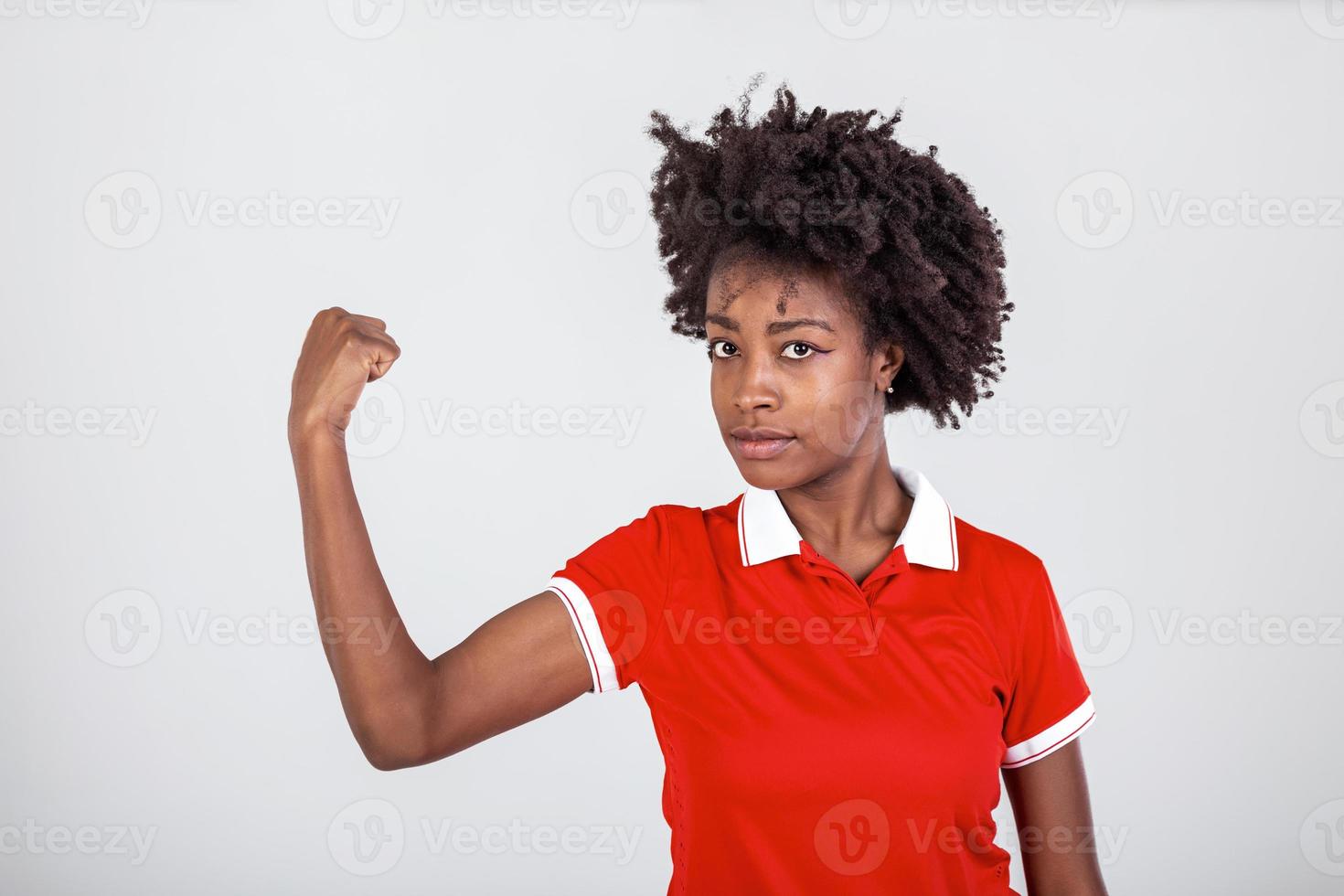 foto di bellissima forte giovane nero donna isolato al di sopra di bianca sfondo mostrando bicipite.ritratto di salutare giovane africano donna flessione braccio muscoli su bianca sfondo