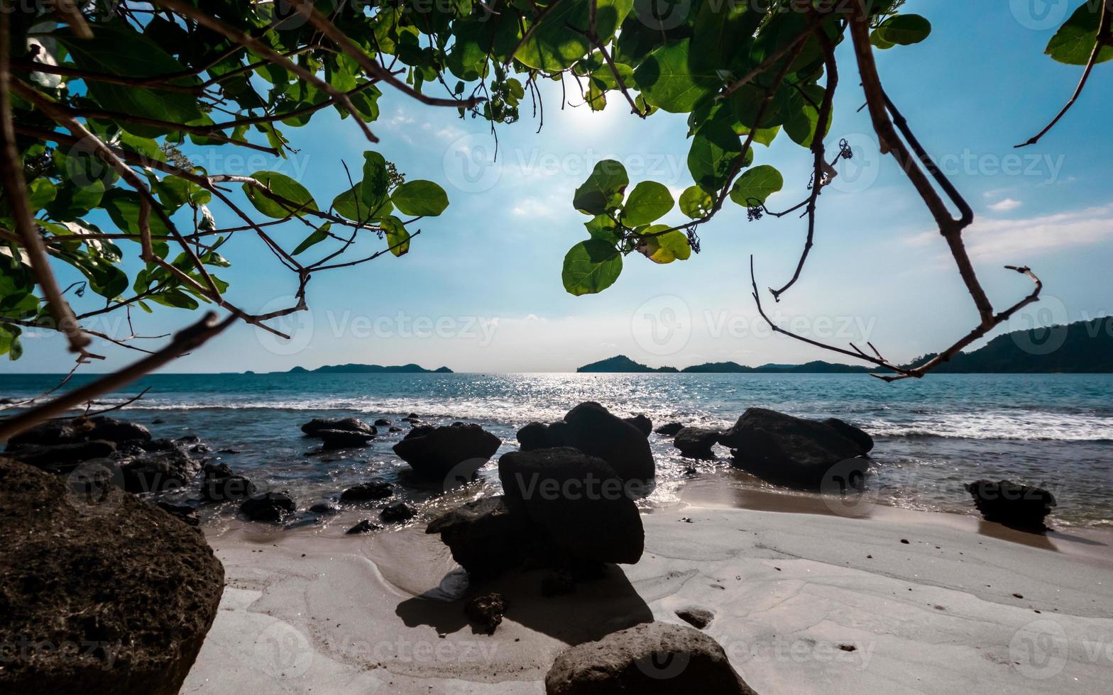 spiaggia soleggiato giorno paesaggio con luce del sole e rocce foto