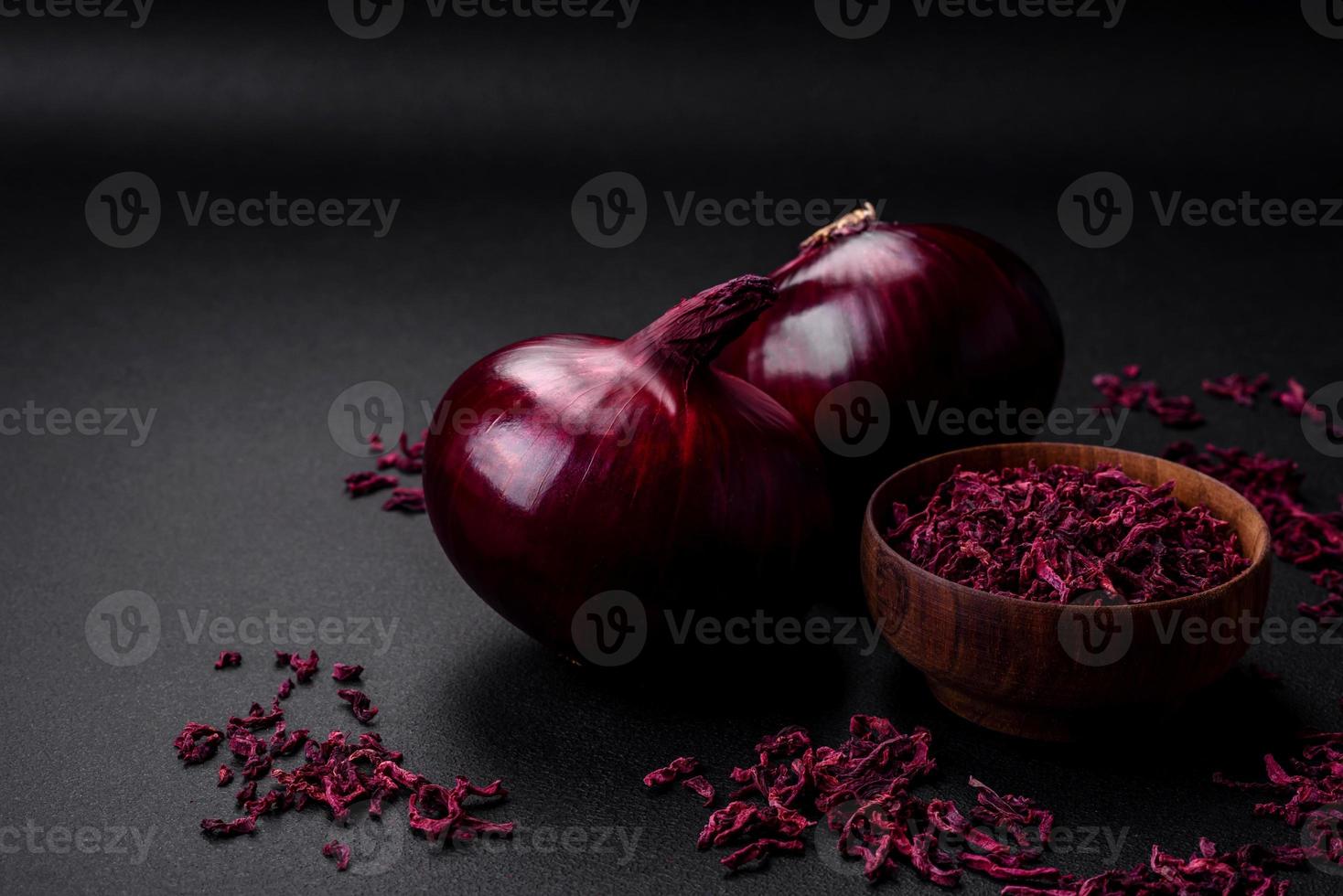 fresco crudo rosso cipolla su buio strutturato calcestruzzo sfondo foto