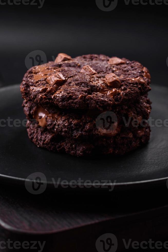 delizioso fresco fiocchi d'avena il giro biscotti con cioccolato su un' nero ceramica piatto foto