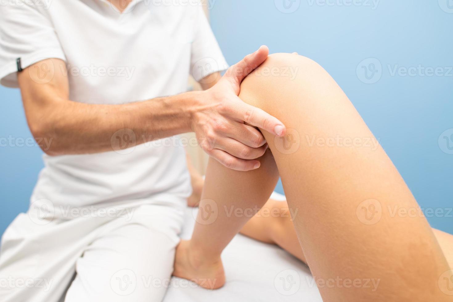 fisioterapista esegue il test del cassetto del ginocchio a una donna foto