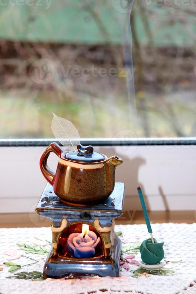 foto di ceramica aroma lampada nel il modulo di un' teiera con un' candela e incenso