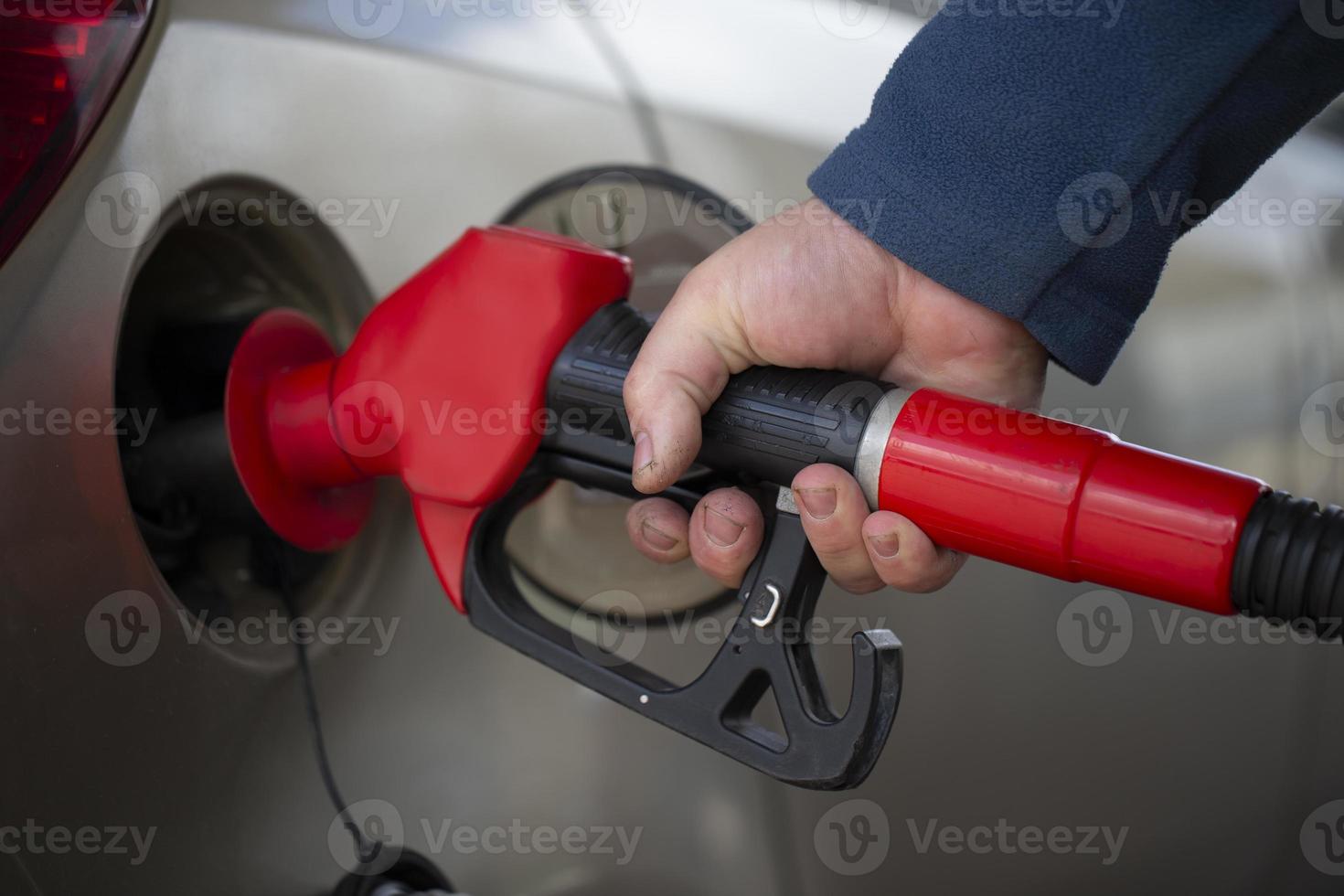 un' mano detiene un' pistola per rifornimento carburante con benzina. foto