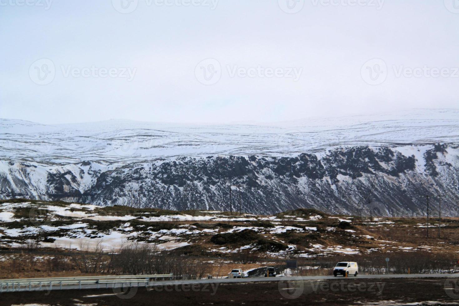 islandese paesaggio con neve coperto montagne e nuvole nel inverno. foto