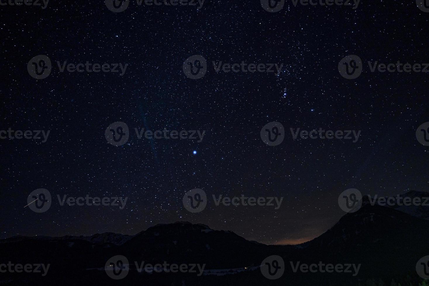 bellissimo cielo con stelle raggiante al di sopra di silhouette paesaggio a notte foto