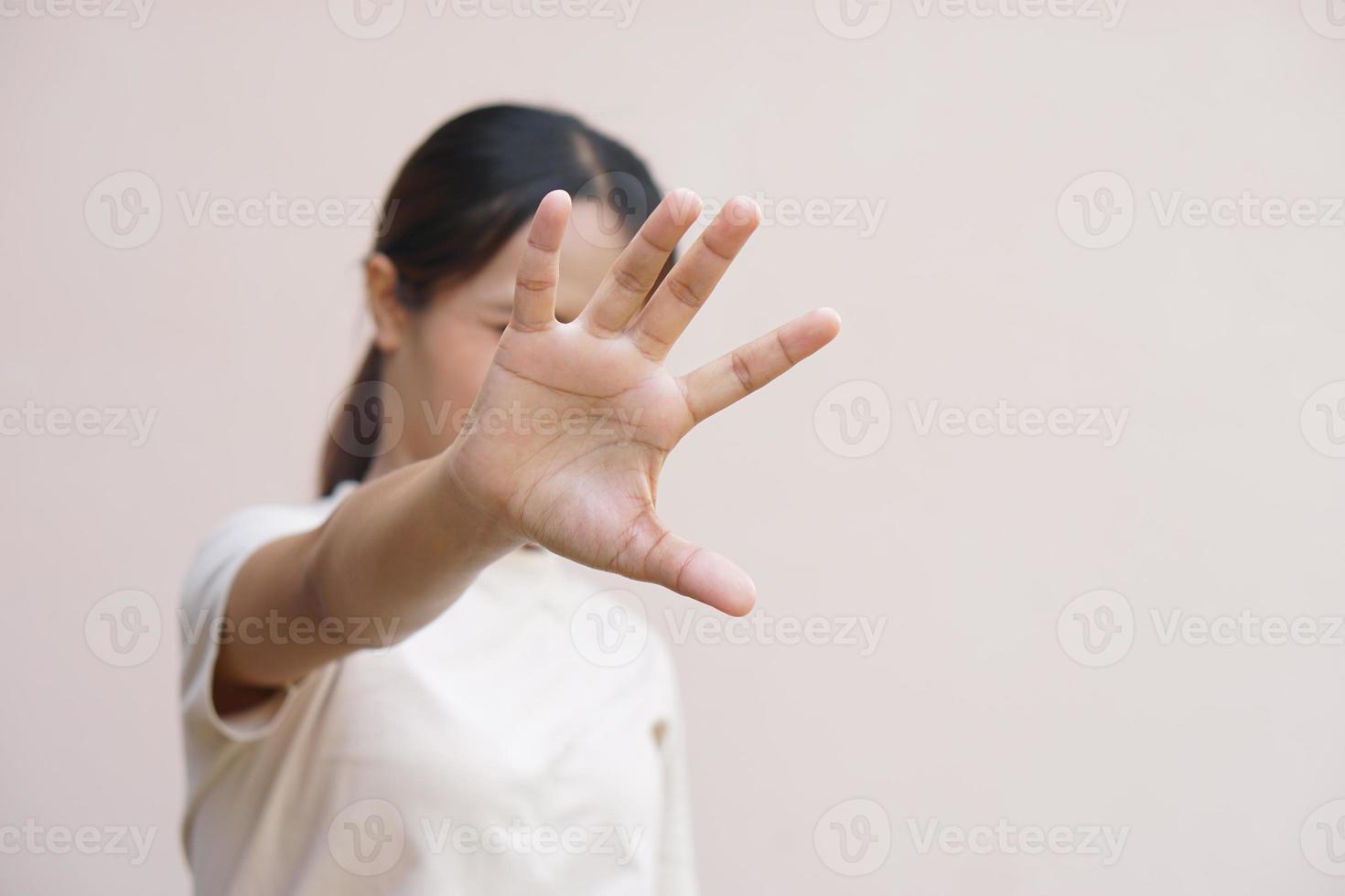 asiatico donna utilizzando sua mani per proteggere contro arrivo pericoli foto
