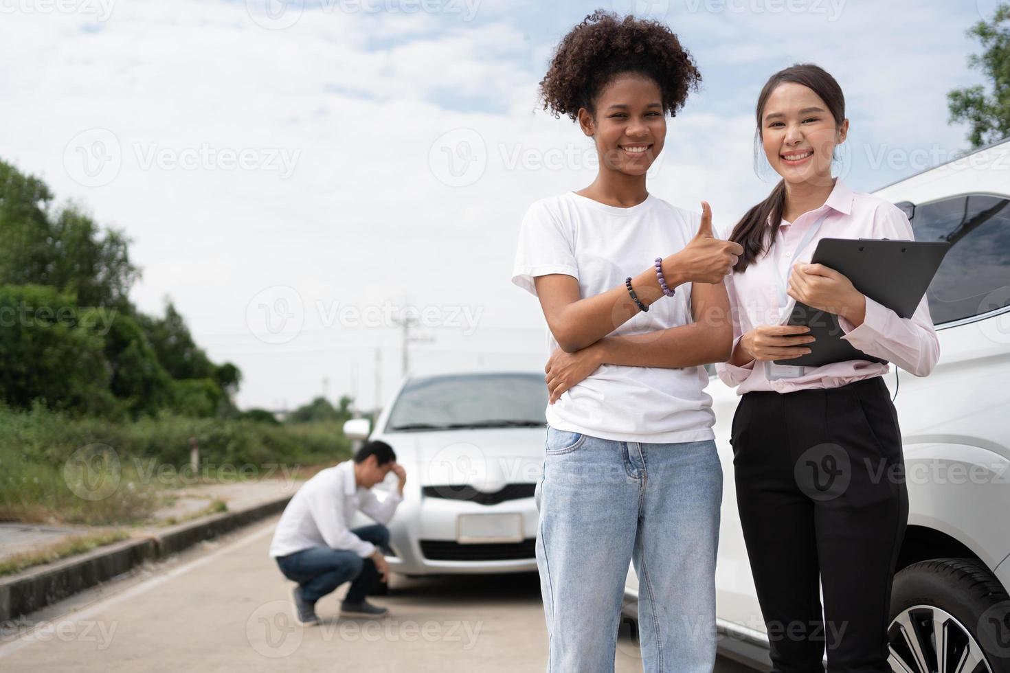 donne autisti parlare per assicurazione agente per l'esame danneggiato auto e cliente controlli su il rapporto Richiesta modulo dopo un incidente. concetto di assicurazione, consigli auto riparazione negozio e auto traffico incidenti. foto