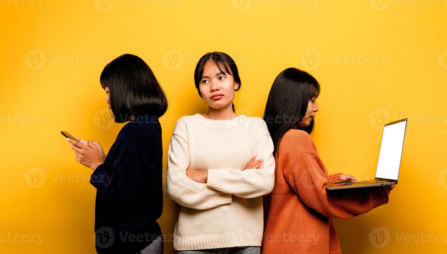 Due asiatico donne Lavorando su il computer portatile e Telefono. a il stesso tempo Due di loro erano comunicare in linea e mostrando contento sorrisi. e fa non cura di il persone in giro lui e il suo amici in linea foto