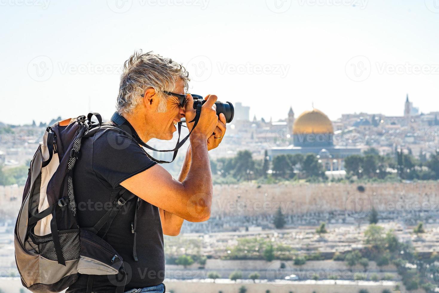 uomo che fotografa i turisti a gerusalemme foto