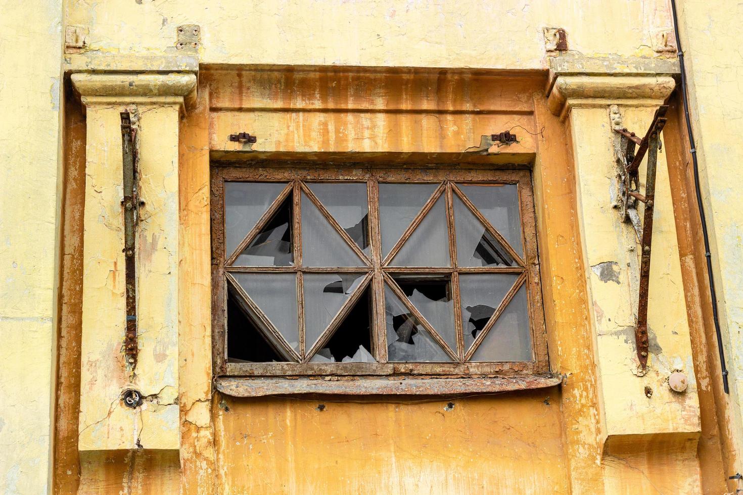 rotto finestre nel il vecchio giallo Casa. foto