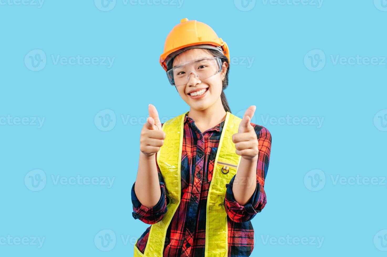 giovane femmina ingegnere indossare giallo casco con punto dito posizione foto