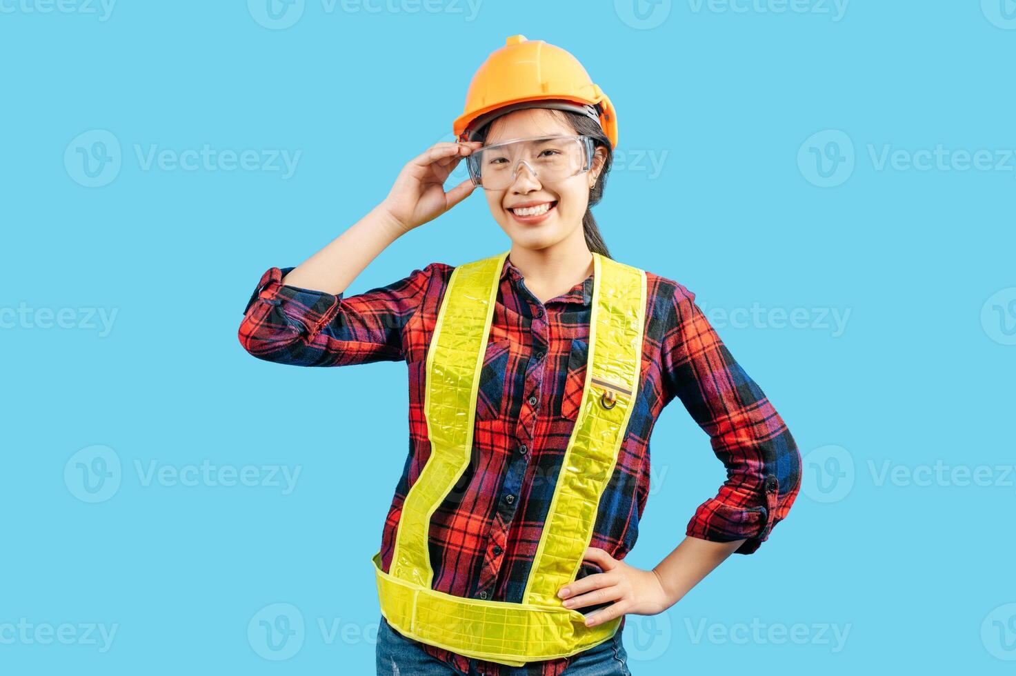 giovane femmina ingegnere nel casco In piedi toccare su sicurezza occhiali posizione foto