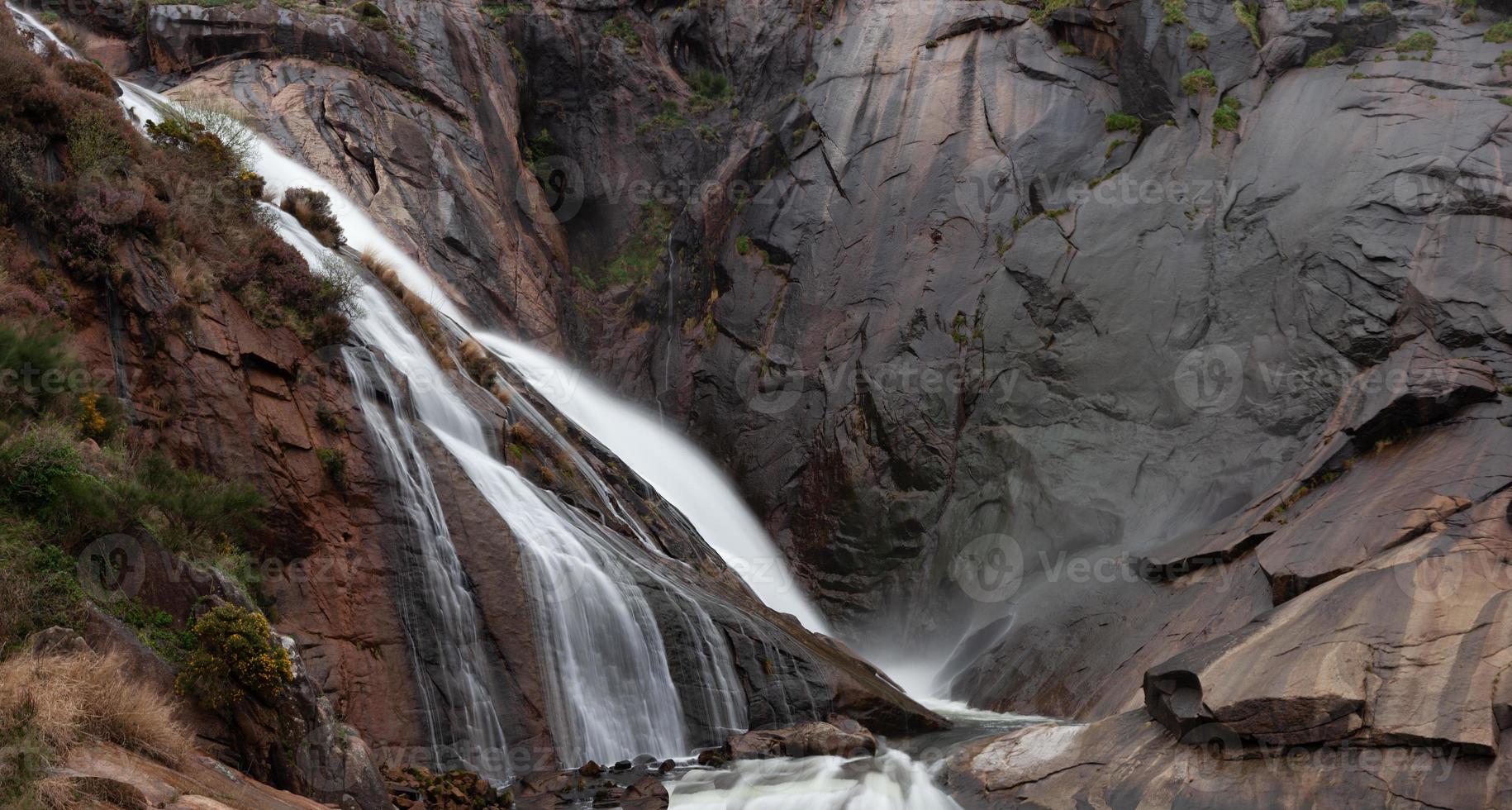 cascata ezaro vicino alla costa della galizia e rocce scure foto