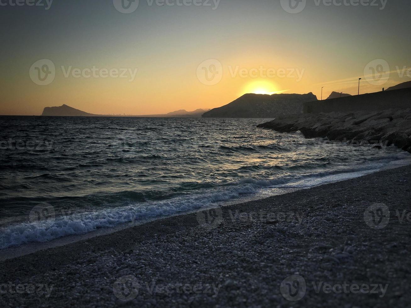 spiaggia mediterranea senza persone al tramonto a calpe, alicante foto