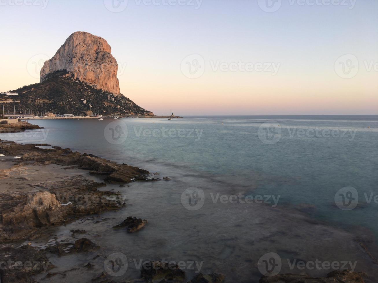 spiaggia mediterranea al tramonto con il penon sullo sfondo a calpe, alicante foto