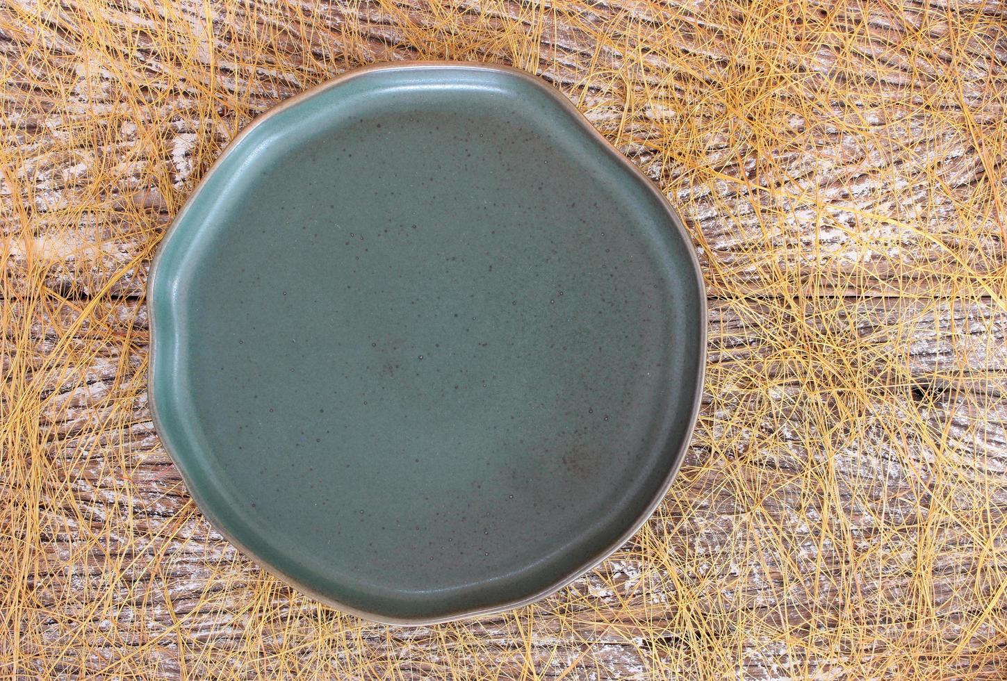 vista dall'alto di un piatto di ceramica vuoto su uno sfondo di tavolo in legno foto