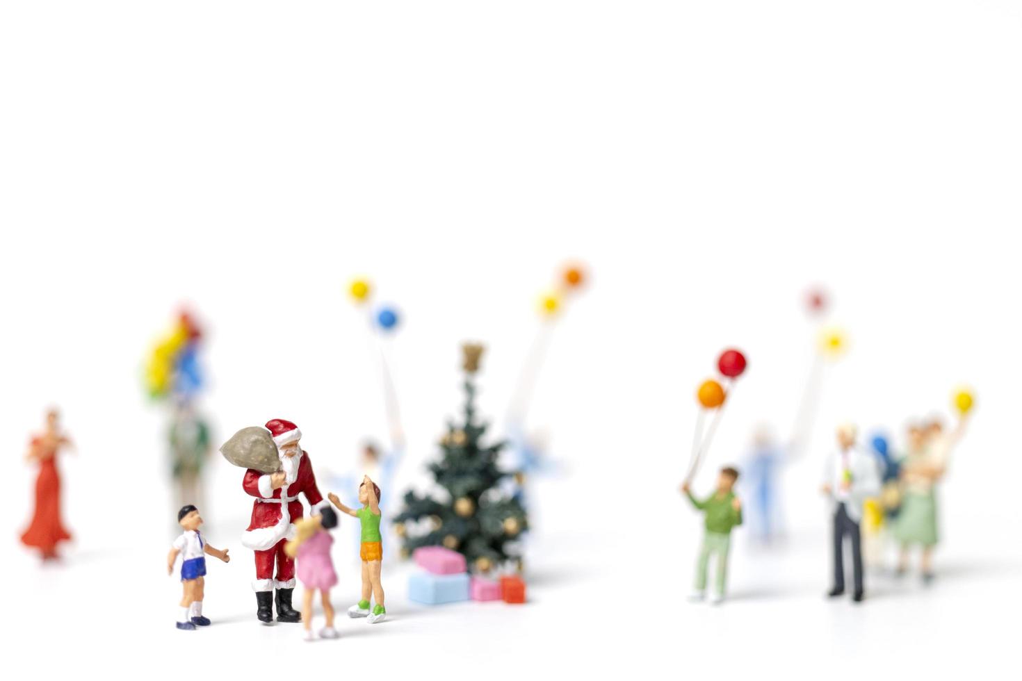 Babbo Natale in miniatura con regali per una famiglia felice, Natale e felice anno nuovo concetto foto