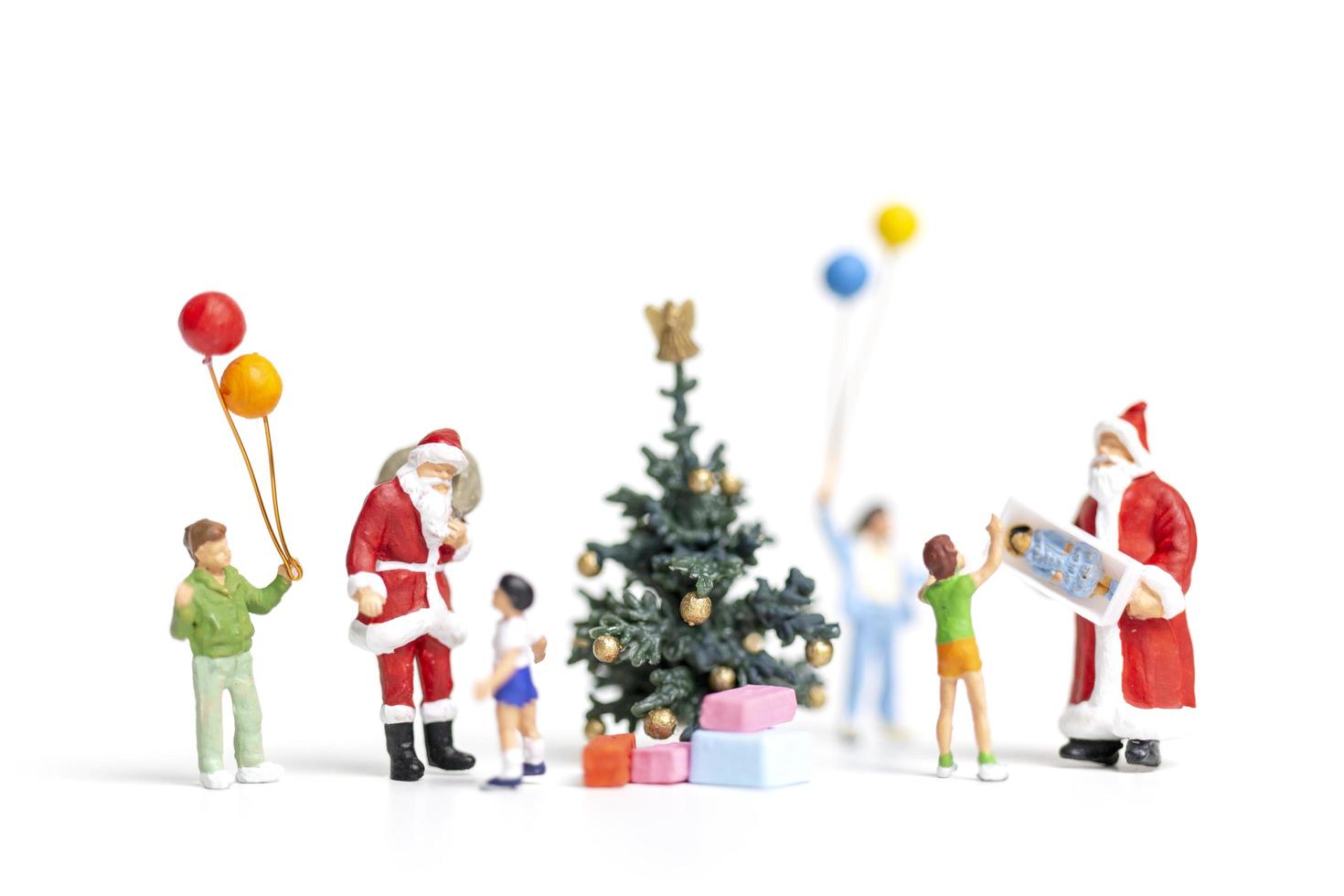 Babbo Natale in miniatura con regali per una famiglia felice, Natale e felice anno nuovo concetto foto