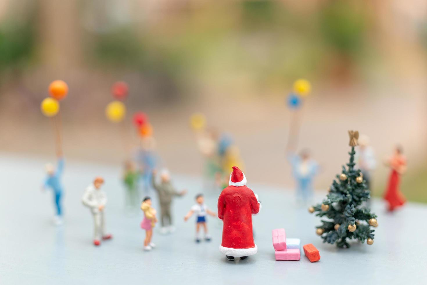 Babbo Natale in miniatura con regali per una famiglia felice, Natale e felice anno nuovo concetto foto