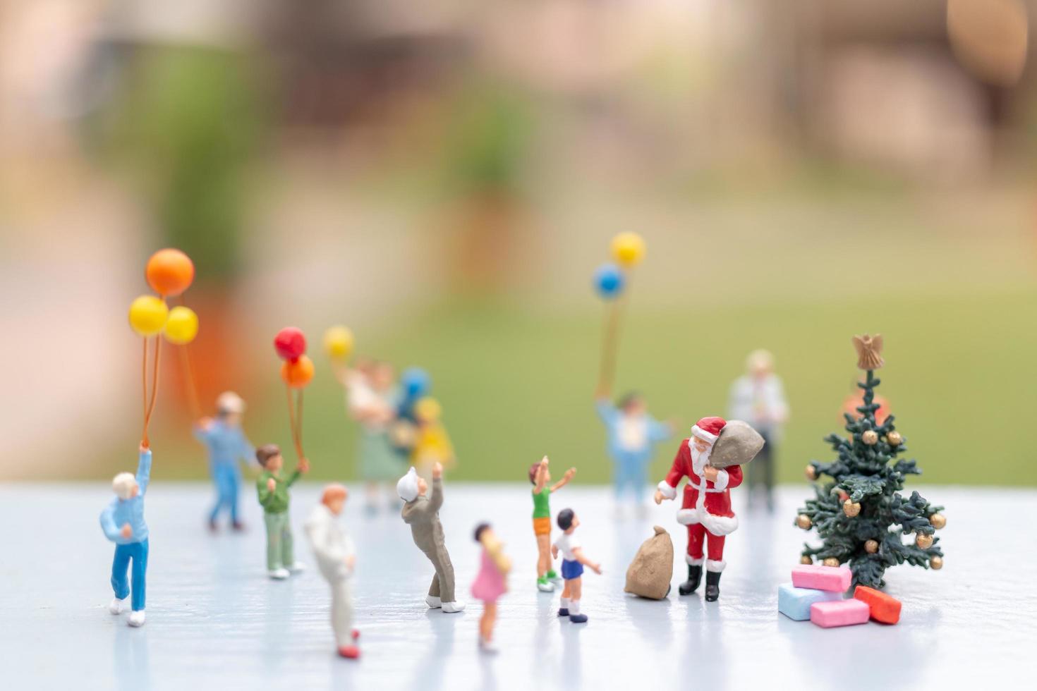 Babbo Natale in miniatura con regali per una famiglia felice, Natale e felice anno nuovo concetto foto