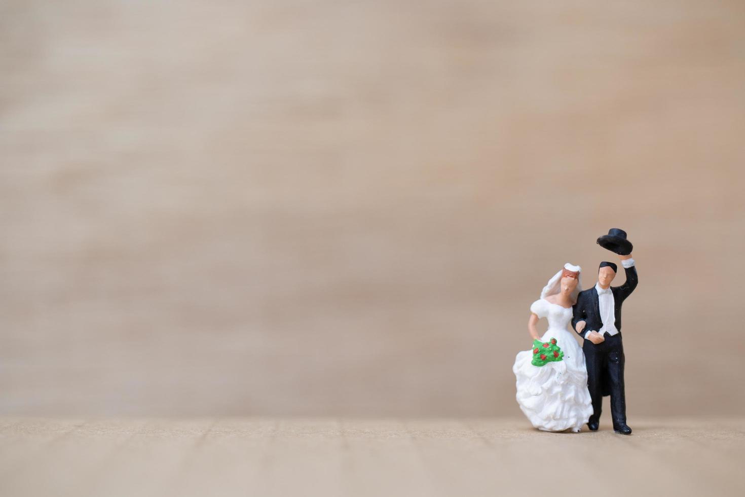 sposi in miniatura su uno sfondo di legno foto
