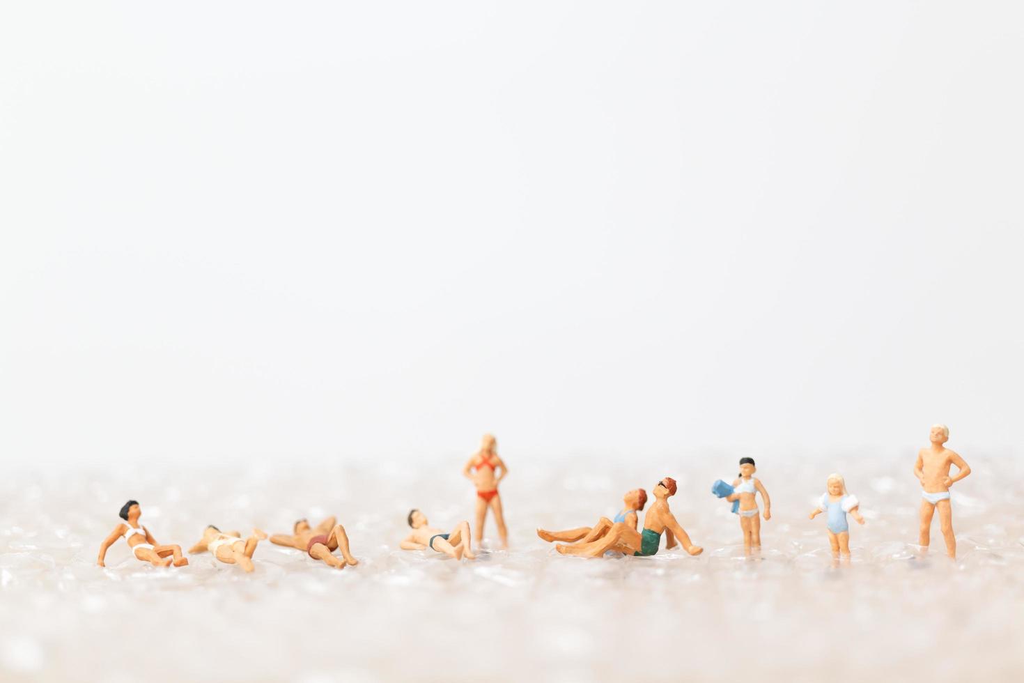 persone in miniatura che indossano costumi da bagno rilassante su una bolla, concetto di vacanza foto
