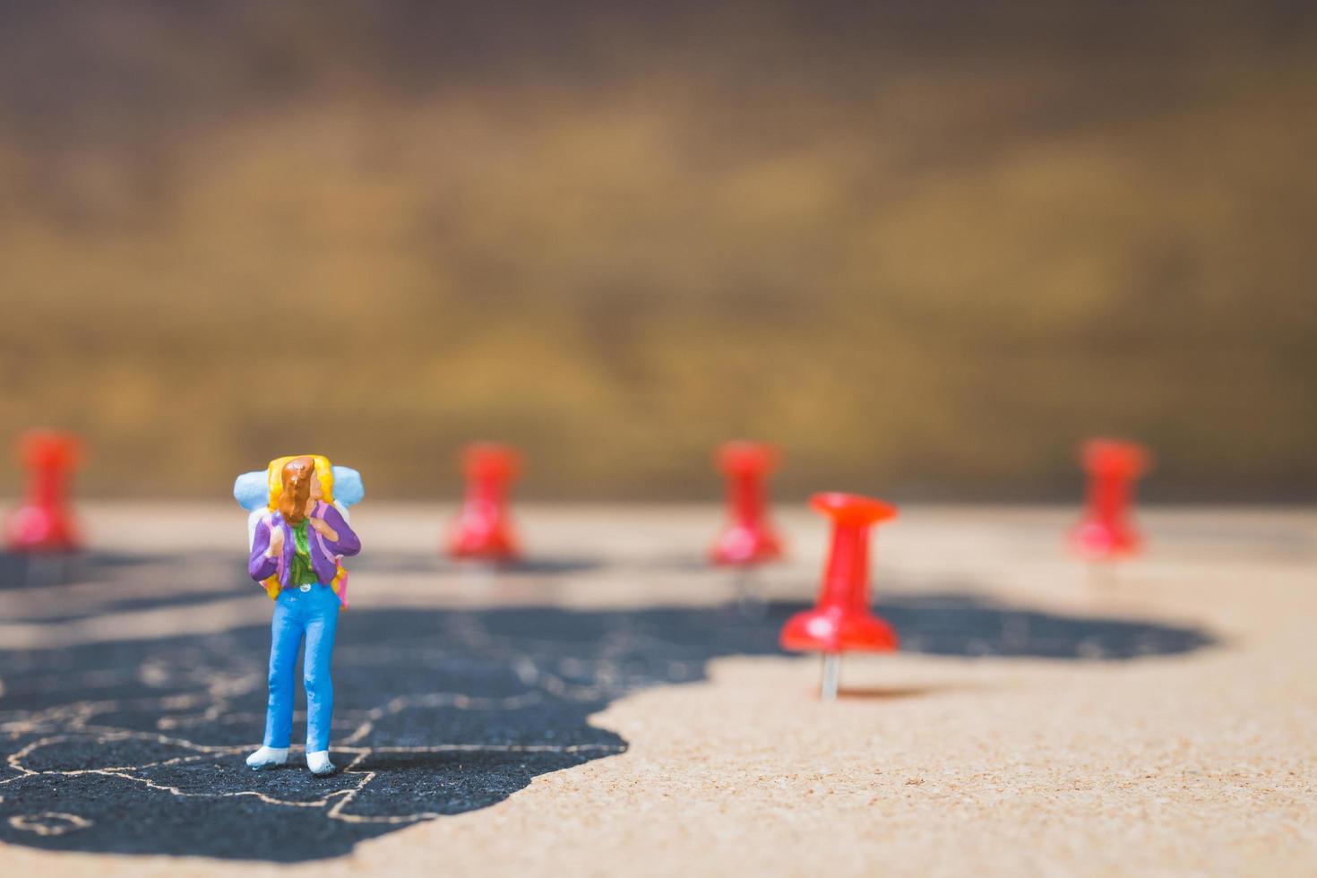 zaino in spalla in miniatura che cammina su una mappa del mondo, turismo e concetto di viaggio foto