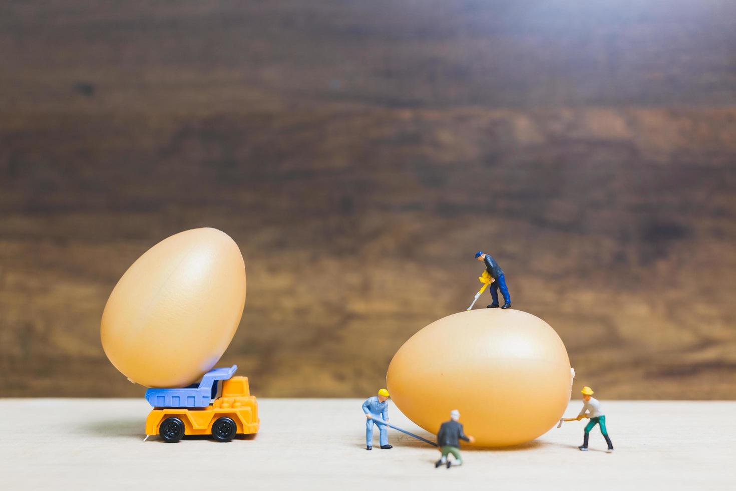 persone in miniatura che lavorano sulle uova di Pasqua per la Pasqua foto