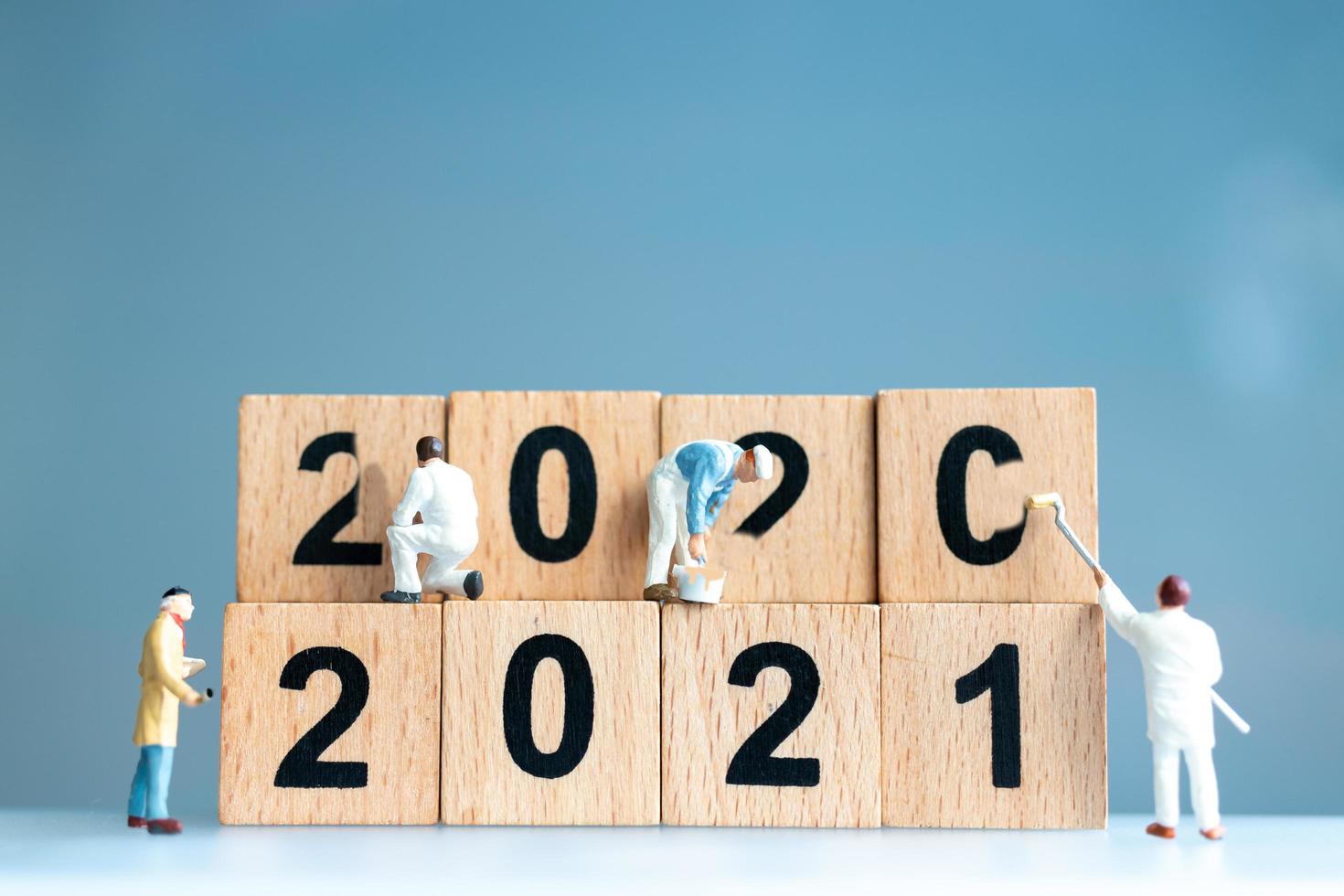 lavoratori in miniatura che collaborano per dipingere il numero 2021 e rimuovere il numero 2020, concetto di felice anno nuovo foto