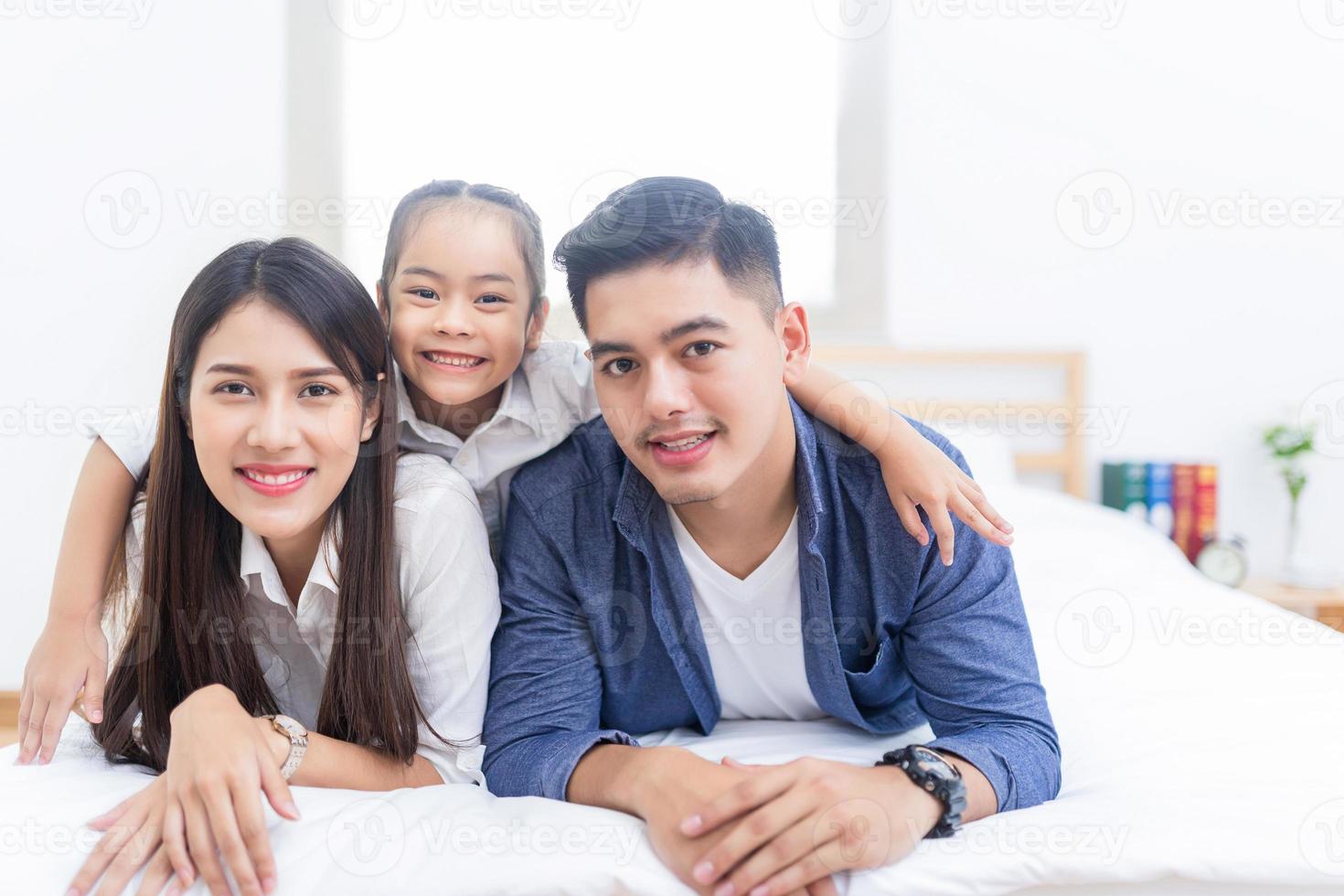 famiglia felice sdraiata su un letto foto