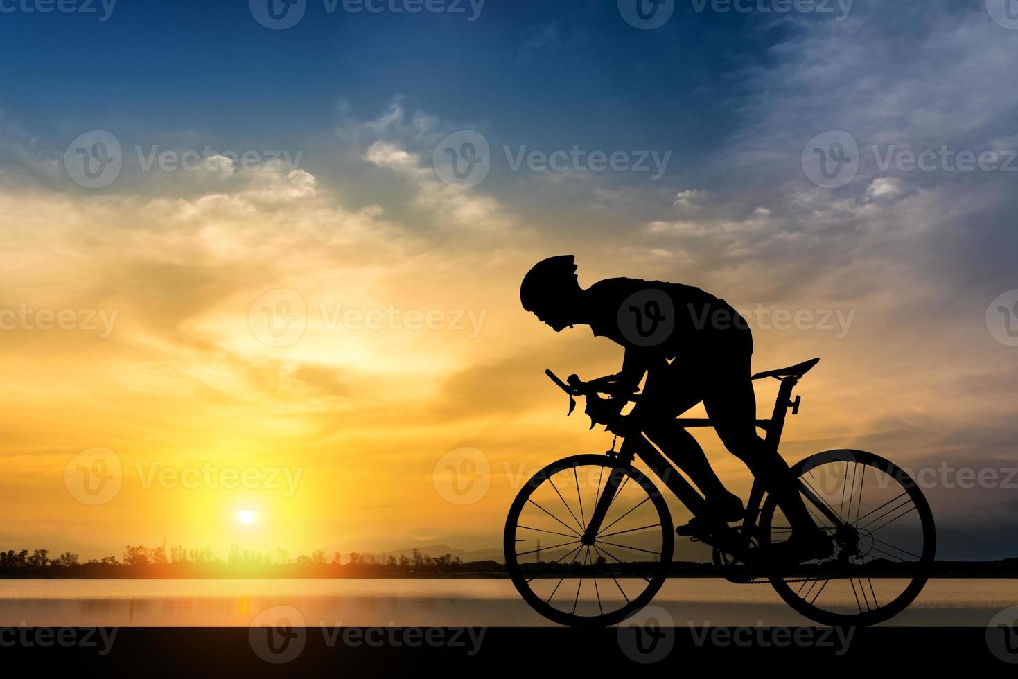 sagoma di un uomo in bicicletta al tramonto foto