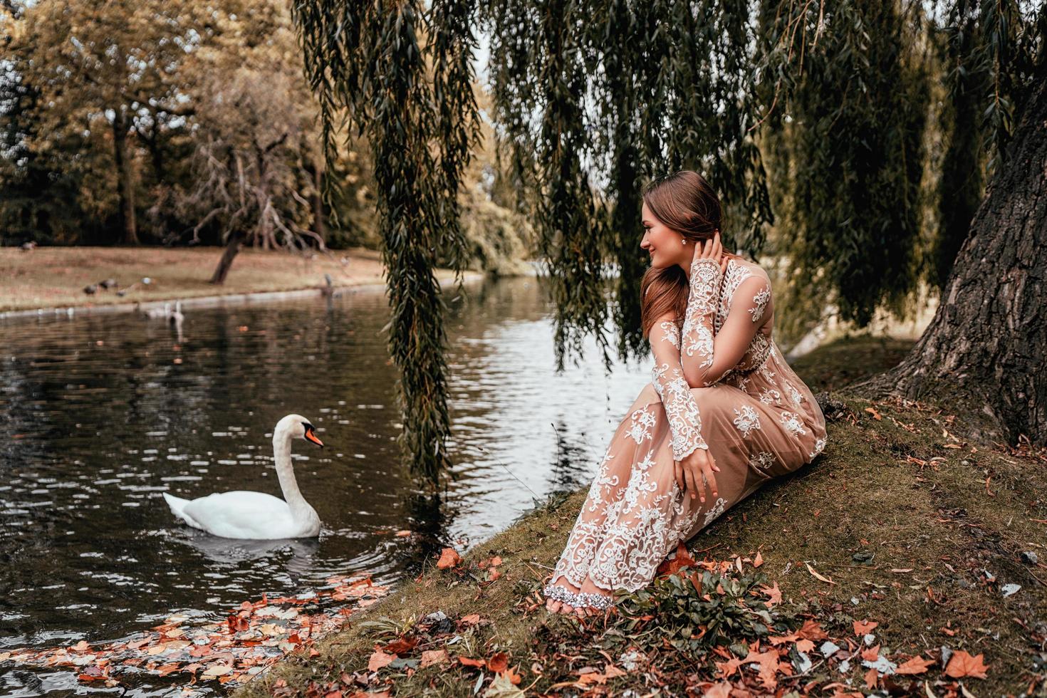 donna che indossa un abito guardando un cigno foto