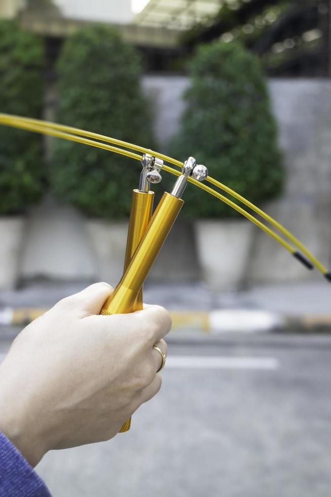 mano della donna che tiene una corda per saltare di velocità foto