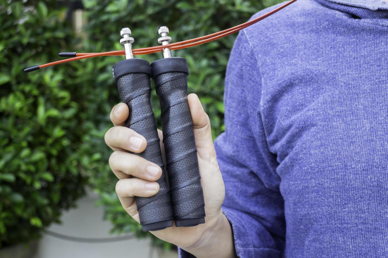 mano della donna che tiene una corda per saltare di velocità foto