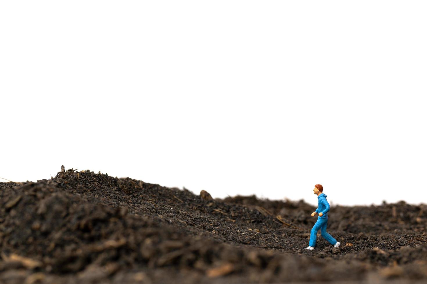 uomo in miniatura che corre sul terreno isolato su uno sfondo bianco, in esecuzione per il concetto di salute foto