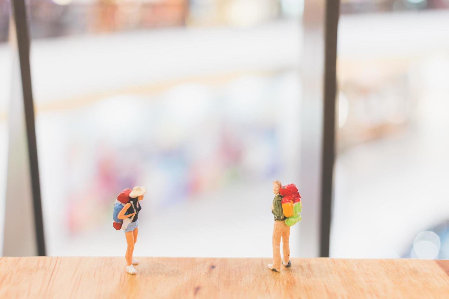 viaggiatori in miniatura che camminano su un pavimento in legno, vacanza e concetto di viaggio foto
